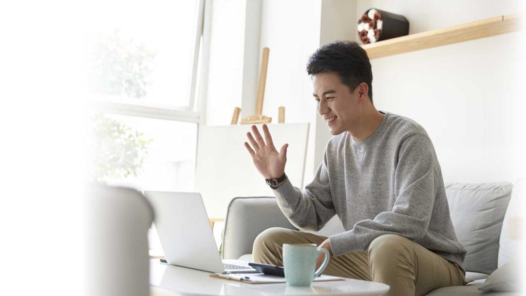 Young man working at home participating internet meeting using video call