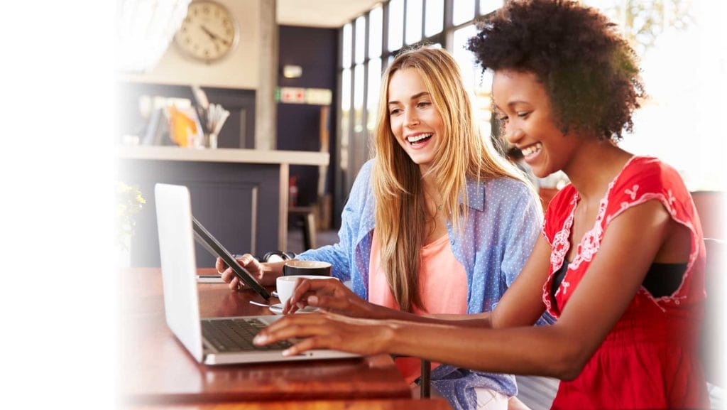 Two women using computers in a coffee shop